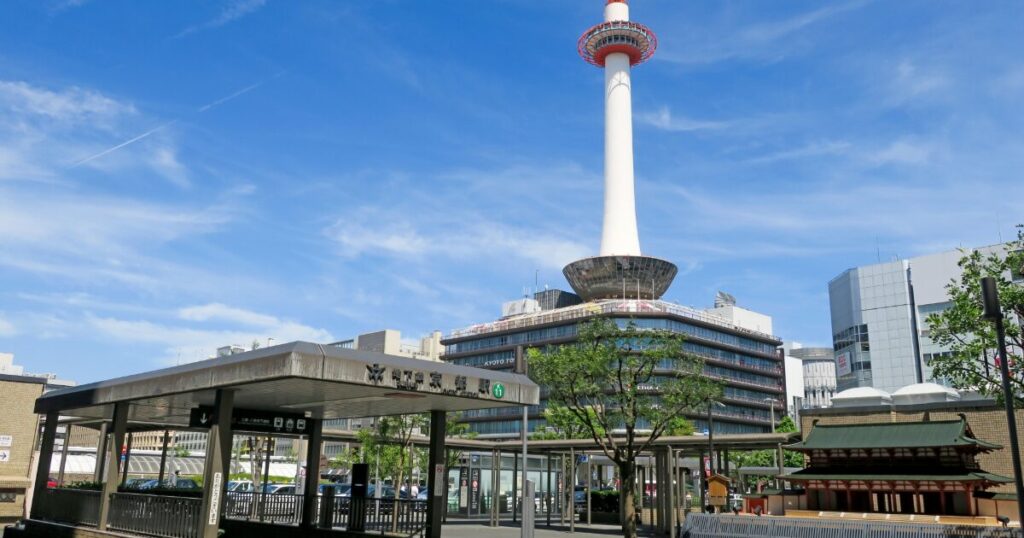 京都駅前にそびえる京都タワーと駅周辺の街並み
